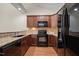 Contemporary kitchen with granite countertops, dark cabinets, and a suite of black appliances at 4105 Gilchrist Dr, Burlington, NC 27215