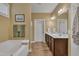 Bright bathroom with a soaking tub and double sink vanity with dark cabinets at 412 Airedale Trl, Garner, NC 27529