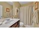 Well-lit bathroom with a marble countertop, decorative shelf, and shower with a curtain at 412 Airedale Trl, Garner, NC 27529