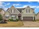 Charming two-story home featuring a two-car garage, stone accents, and professionally landscaped front yard at 412 Airedale Trl, Garner, NC 27529