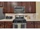 Close up of kitchen appliances and granite counters with wood cabinets at 412 Airedale Trl, Garner, NC 27529