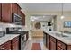 Modern kitchen features granite countertops, stainless appliances, and a view of the living room at 412 Airedale Trl, Garner, NC 27529