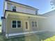 The backyard has a covered concrete patio and beige siding with dark trim at 437 Earnest Way, Kenly, NC 27542