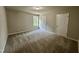 Neutral carpeted bedroom with a window and paneled doors at 437 Earnest Way, Kenly, NC 27542