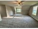 Spacious carpeted bedroom with plenty of sunlight from double windows and a ceiling fan at 437 Earnest Way, Kenly, NC 27542