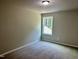Clean bedroom with carpet and a well-lit window showing the outside at 437 Earnest Way, Kenly, NC 27542