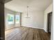 Bright dining room with hardwood floors, a modern chandelier, and large windows at 437 Earnest Way, Kenly, NC 27542