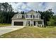 Charming two-story home featuring a two-car garage, well-manicured lawn, and classic design elements at 437 Earnest Way, Kenly, NC 27542