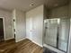 Bright main bathroom featuring wood floors, a glass-enclosed shower, and neutral wall colors at 437 Earnest Way, Kenly, NC 27542