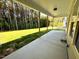 Wide covered concrete patio overlooks a grassy backyard with trees and a sunny sky at 437 Earnest Way, Kenly, NC 27542