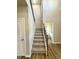 Carpeted staircase with wooden railing and view into the bathroom at 437 Earnest Way, Kenly, NC 27542