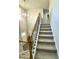 Carpeted staircase with a black metal railing and wood trim at 437 Earnest Way, Kenly, NC 27542
