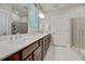 Modern bathroom with a double vanity, white tile floors, and a walk-in shower at 4408 Walker Hallow St, Raleigh, NC 27616