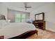 Well-lit bedroom with a ceiling fan, natural wood floors, a bed, and a dresser at 4408 Walker Hallow St, Raleigh, NC 27616