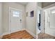 Bright entryway with wood flooring, access to a bathroom and bedroom, and a front door with glass at 4408 Walker Hallow St, Raleigh, NC 27616