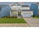 Charming two-story home with a well-manicured lawn, a covered porch, and an attached two-car garage at 4408 Walker Hallow St, Raleigh, NC 27616