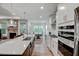 Bright, open kitchen with stainless steel appliances, a large island, and hardwood floors at 4408 Walker Hallow St, Raleigh, NC 27616