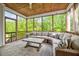Relaxing screened porch with wood ceiling, comfortable sectional seating, an outdoor ceiling fan, and scenic views at 4408 Walker Hallow St, Raleigh, NC 27616