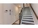 Hallway and staircase feature wood flooring, white walls, and a dark wood banister at 444 Deercroft Dr, Apex, NC 27539