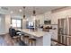 Open-concept kitchen featuring a quartz island with seating and stainless steel appliances overlooking living area at 444 Deercroft Dr, Apex, NC 27539