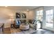 Cozy living room with neutral walls, grey couch, accent pillows, and large windows providing natural light at 444 Deercroft Dr, Apex, NC 27539