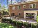 Back of brick home featuring a wooden deck, green shrubs, and manicured lawn at 4533 Wood Valley Dr, Raleigh, NC 27613