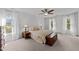 Bright bedroom featuring large windows, ceiling fan, and neutral carpet at 4533 Wood Valley Dr, Raleigh, NC 27613