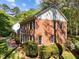 Brick home with shutters, mature landscaping, and a paved walkway at 4533 Wood Valley Dr, Raleigh, NC 27613