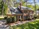 Brick home with a well-maintained lawn, mature trees, and a side-entry garage at 4533 Wood Valley Dr, Raleigh, NC 27613