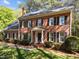 Charming brick home featuring a classic colonial design with black shutters and a manicured lawn at 4533 Wood Valley Dr, Raleigh, NC 27613