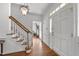 Bright foyer featuring hardwood floors, staircase, and natural light filtering through the front door at 4533 Wood Valley Dr, Raleigh, NC 27613