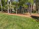Traditional brick home with a manicured lawn and mature trees in a peaceful, wooded setting, offering classic charm at 4533 Wood Valley Dr, Raleigh, NC 27613