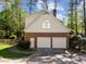 Two-car garage with brick and siding, alongside a walkway and landscaping at 4533 Wood Valley Dr, Raleigh, NC 27613