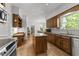 Open kitchen with wood cabinets, granite counters, island, and a built-in desk area at 4533 Wood Valley Dr, Raleigh, NC 27613