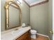 Stylish half-bath with decorative mirror and floral wallpaper border at 4533 Wood Valley Dr, Raleigh, NC 27613