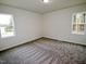 Bright bedroom with carpet flooring and natural light from two windows at 58 S Grace Way, Henderson, NC 27537