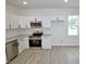 Bright and modern kitchen with stainless steel appliances and light-colored granite countertops at 58 S Grace Way, Henderson, NC 27537