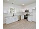 Bright kitchen featuring stainless steel appliances, white cabinets, and hardwood floors at 58 S Grace Way, Henderson, NC 27537