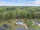 Overhead view of a white farmhouse style home with lush green landscaping, trees, and surrounding pond at 6024 Lunenburg Dr, Raleigh, NC 27603