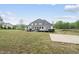 A full view of the back exterior of the home with large yard and pond at 6024 Lunenburg Dr, Raleigh, NC 27603
