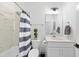 Cozy bathroom showcasing a shower with blue and white striped curtain and a single sink vanity at 6024 Lunenburg Dr, Raleigh, NC 27603