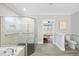 Bathroom with glass enclosed shower featuring white marble tile and an open doorway to the bedroom at 6024 Lunenburg Dr, Raleigh, NC 27603