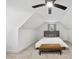 Sloped ceiling bedroom showcasing a modern ceiling fan and a comfortable bed with a seating bench at 6024 Lunenburg Dr, Raleigh, NC 27603