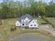 Striking white modern farmhouse with a landscaped yard and a circular driveway at 6024 Lunenburg Dr, Raleigh, NC 27603