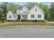 Inviting two-story home with a classic white facade, stone foundation, and well-manicured lawn at 6024 Lunenburg Dr, Raleigh, NC 27603