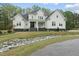 Charming white farmhouse-style home featuring a covered porch, stone accents and professional landscaping at 6024 Lunenburg Dr, Raleigh, NC 27603