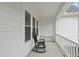 Cozy porch with a black rocking chair and views of windows and white railings at 6024 Lunenburg Dr, Raleigh, NC 27603