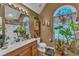 Charming bathroom with wooden vanity, plants, and arched window with decorative curtains at 604 Young Forest Dr, Wake Forest, NC 27587