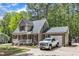 Home with attached garage and a charming front porch, surrounded by mature trees and a yard at 604 Young Forest Dr, Wake Forest, NC 27587