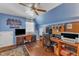 Blue-walled home office featuring two wooden desks, hardwood floors, a ceiling fan, and a window at 604 Young Forest Dr, Wake Forest, NC 27587